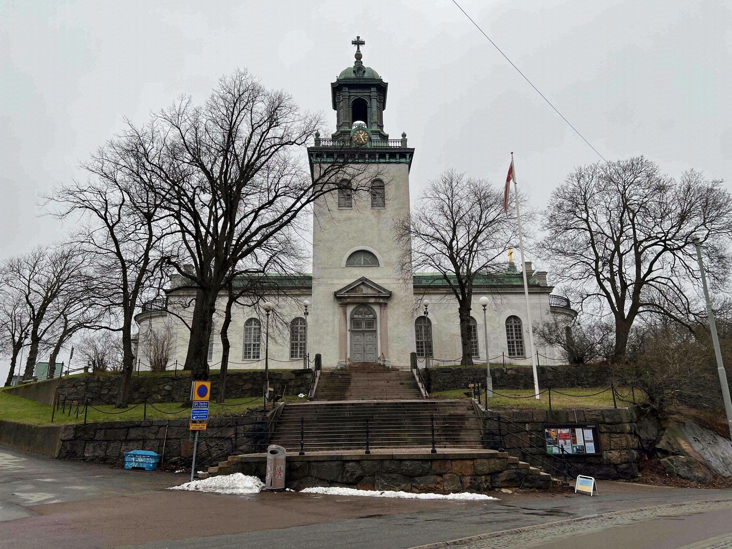 Die weiße neoklassizistische Carl Johans kyrka in Majorna auf einer Anhöhe mit grüner Turmkuppel und Freitreppe.